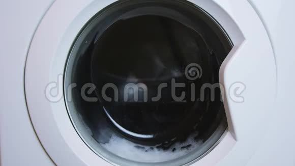 普通白色家用洗衣机洗涤衣物视频的预览图
