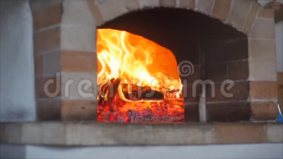 慢动作的框架就像在披萨炉里刚烤好的木柴正在燃烧把披萨放进烧木头的披萨炉里视频的预览图