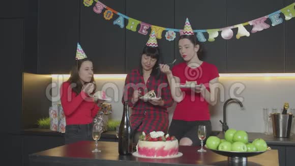 快乐的女人在家厨房吃生日蛋糕视频的预览图
