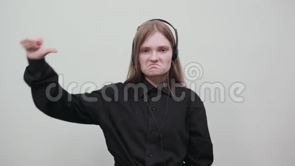 穿黑色衬衫的女人竖起大拇指听音乐戴耳机视频的预览图