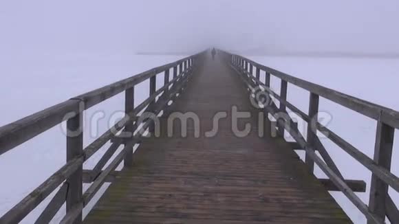 上午的雾在木桥和一个步行的学生视频的预览图