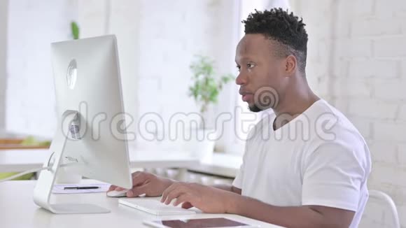 专注办公桌面工作的非洲男子视频的预览图