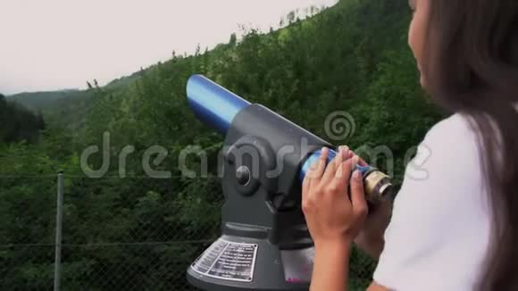 女孩用旅游望远镜看山上的古堡视频的预览图