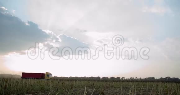 在收割期间一辆有大拖车的卡车正行驶在靠近农田的道路上视频的预览图