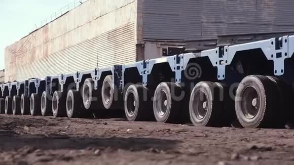 有许多轮子的汽车拖网用来运输笨重的货物视频的预览图