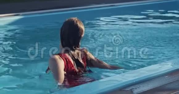 穿红色衣服的年轻女子把自己推到水里开始游泳4K视频的预览图