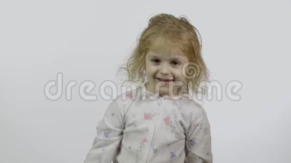 穿着滑稽头饰的睡衣的小女孩挥舞着她的手问候语视频的预览图