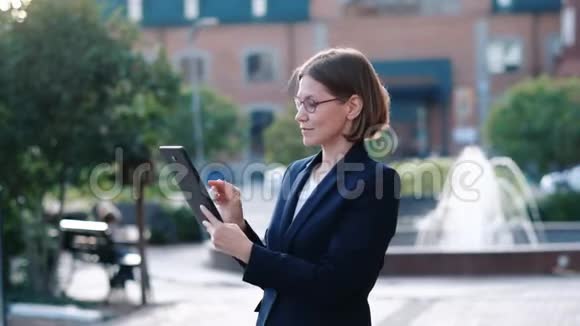 年轻商务女性使用平板电脑户外视频的预览图