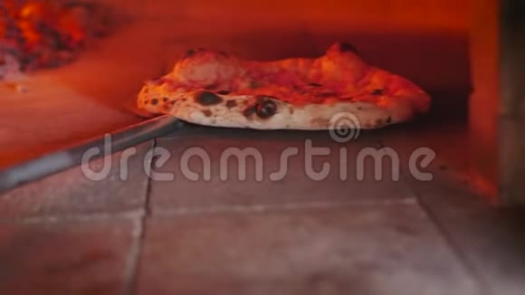 检查披萨是否准备好用比萨饼皮把它从披萨烤箱里拉出来视频的预览图