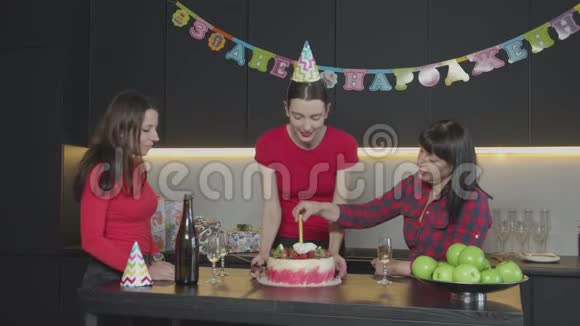 派对帽子剪生日蛋糕的快乐女人视频的预览图