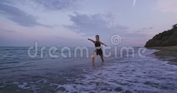 迷人的年轻女性在海边练习瑜伽早上伸展身体集中注意力视频的预览图