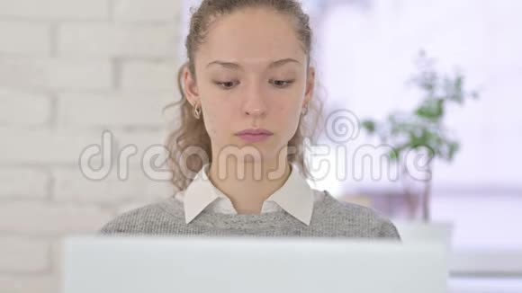 年轻的拉丁女人在手提电脑上做大拇指视频的预览图
