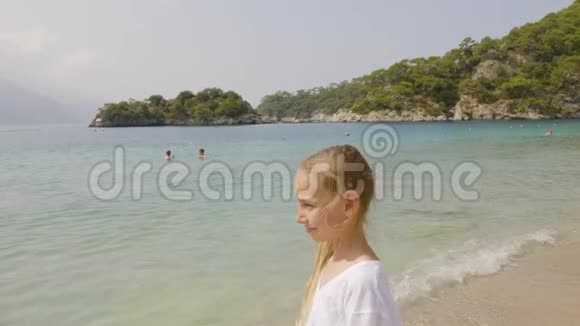 在碧海和青山景观上穿着白色连衣裙的肖像少年女孩看海看山的旅游女孩视频的预览图