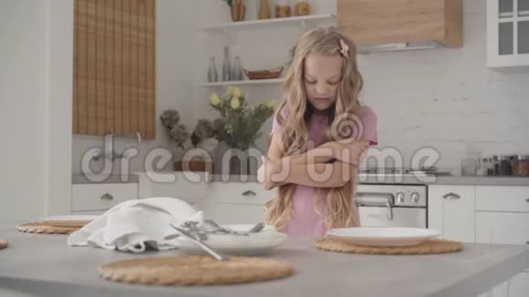 可爱的年轻白种人少女站在现代厨房愤怒地看着远方漂亮的金发少年视频的预览图