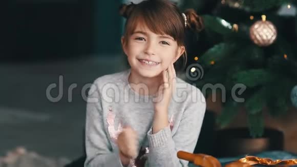 在圣诞树附近微笑的小女孩视频的预览图