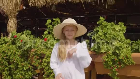 嬉戏的少年女孩在夏季植物背景上跳舞前镜头草屋里的小女孩在夏天跳舞视频的预览图