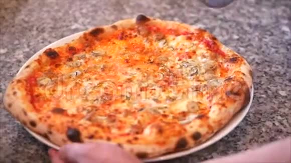 新鲜的披萨将一个意大利香肠披萨切成多片用比萨饼切割机视频的预览图