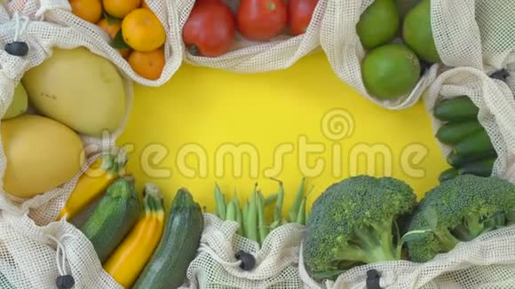 五颜六色的水果和蔬菜在可重复使用的袋子在黄色的背景零浪费减少塑料废物概念视频的预览图