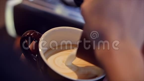 专业咖啡师制作新鲜的磨碎咖啡咖啡师制作拉丁艺术将牛奶倒入杯子同时制作视频的预览图