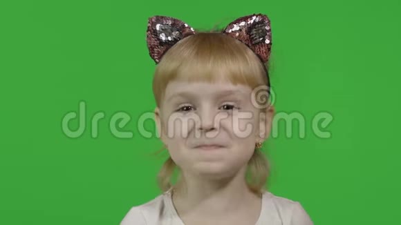 戴着猫头巾的女孩摸着她的耳朵做着脸四岁快乐的孩子视频的预览图