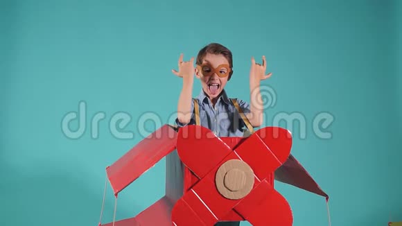 穿着纸板飞机休闲装的滑稽小男孩视频的预览图