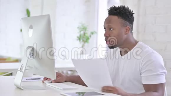 休闲非洲男子在办公室用桌面做文书工作视频的预览图