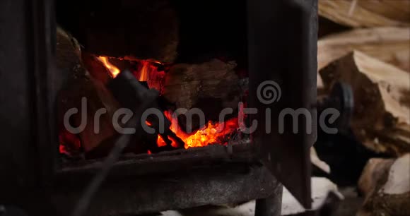 树在壁炉里燃烧得很漂亮男手把木柴放进炉子里壁炉里着火了4好的中等视频的预览图
