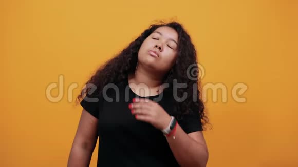 非裔美国卷毛的女人把手放在下巴上看着一边想着视频的预览图
