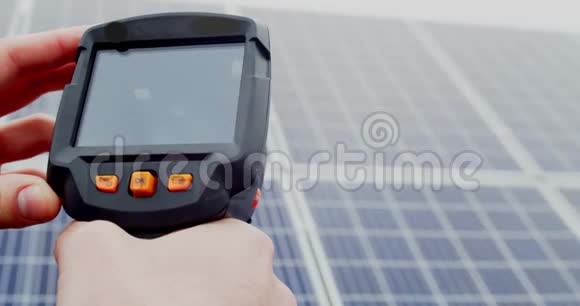 一个拿着热成像仪的工人正在把它指向4k的太阳能电池板视频的预览图