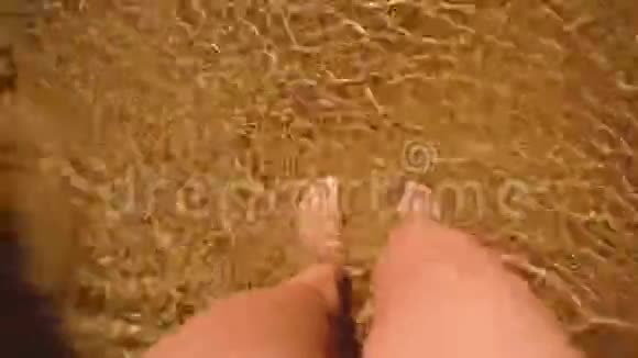 女人用水晶水在沙滩上散步海上波涛从上往下看腿视频的预览图