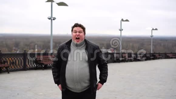 放大肥胖愤怒的男人的肖像看着相机尖叫视频的预览图