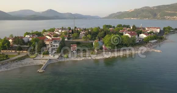 一个美丽的小镇在湖上的空中镜头地平线上的群山4k视频的预览图