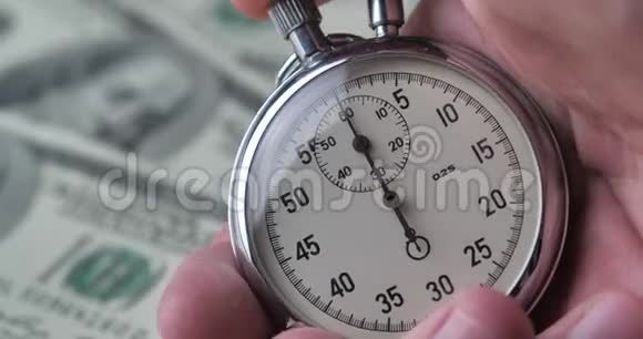 特写一个人在金钱背景上启动秒表时间就是金钱最后期限概念视频的预览图
