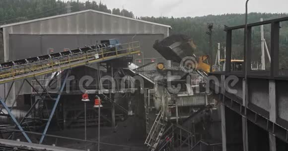 挖掘机缓慢地向采矿车装载挖掘机在大型自卸汽车上装煤把煤装进去视频的预览图