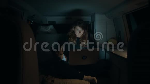 夜间露营车里有笔记本电脑的女人视频的预览图