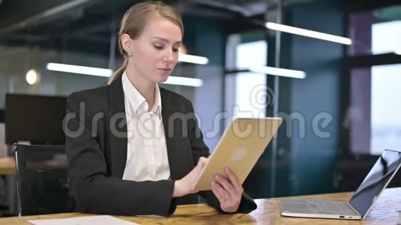 勤劳的年轻女商人在现代办公室使用平板电脑视频的预览图