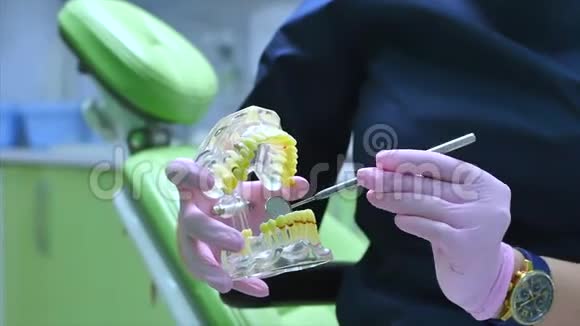 女牙医在诊所为女病人治疗牙齿牙医向病人展示下颚模型如何视频的预览图