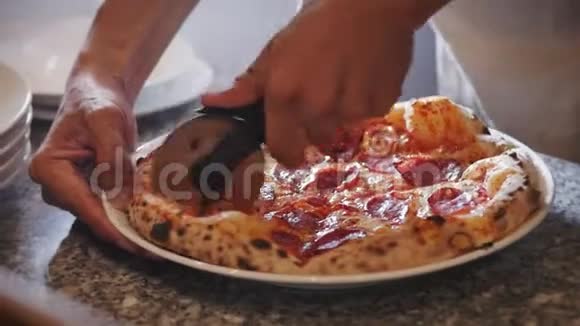 新鲜的披萨将一个意大利香肠披萨切成多片用比萨饼切割机视频的预览图