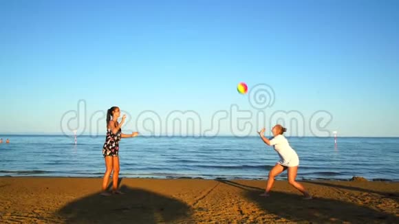 青少年女孩在日落时在海边打沙滩排球视频的预览图