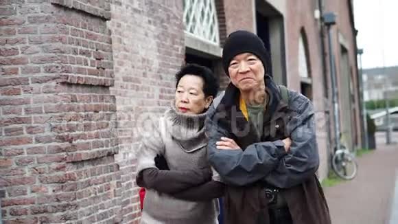 在荷兰阿姆斯特丹的住宅区散步的亚洲老夫妇视频的预览图