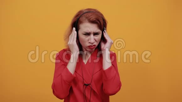 失望的女人戴着漂亮的耳机手拿着它看上去很严肃视频的预览图