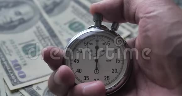 特写一个人在金钱背景上启动秒表时间就是金钱最后期限概念视频的预览图