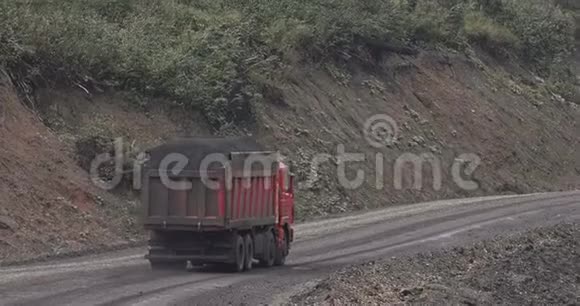 卡车的航空测量倾斜覆盖的自卸汽车沿着乡村道路运输煤炭卡车在肮脏的乡村行驶视频的预览图