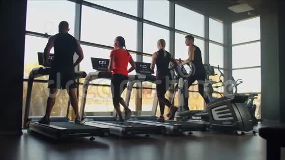 健身夫妇一起在健身房的跑步机上跑步帅哥在健身机器上训练女人视频的预览图