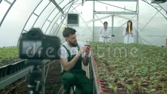 年轻农民在温室里录制视频视频的预览图