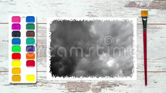 创意时间圈视频4k的桌子用画笔颜料一张纸和漂浮的灰色雨云视频的预览图