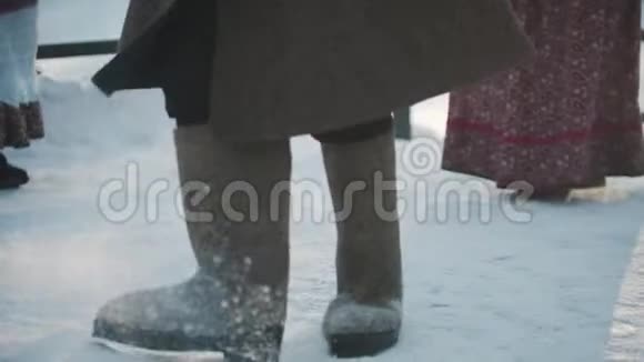 俄罗斯传统一个穿靴子和羊皮大衣的男人在雪地里跳舞视频的预览图