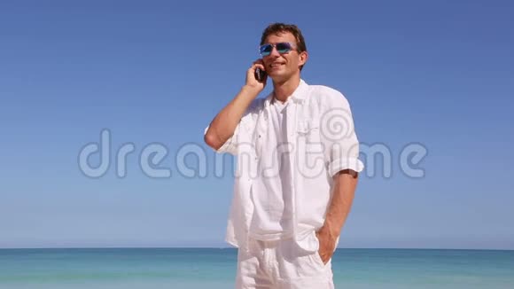 年轻人在夏威夷海滩上用智能手机聊天度假旅游概念视频的预览图
