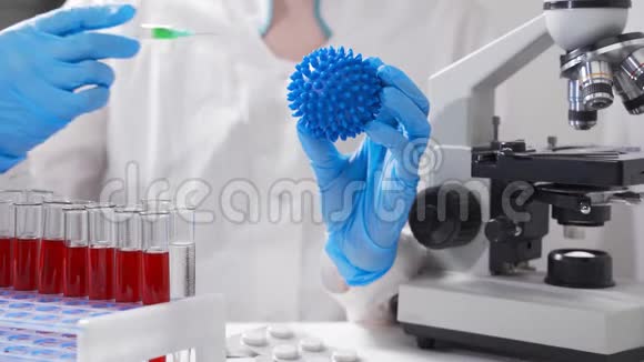 一位科学家手里拿着一种病毒模型正在测试一种新药或疫苗视频的预览图