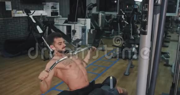 年轻的健美男子集中精力在健身班举重锻炼腹肌肌肉视频的预览图